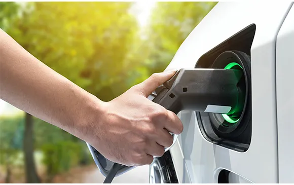 Person plugging electric vehicle into commercial EV charging station in Atlanta, GA