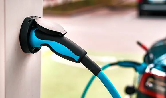 Close-up of electric vehicle charging connector plugged into EV charger in Atlanta, GA