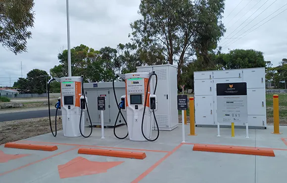 Public electric vehicle charging station with multiple charging units and cars charging.