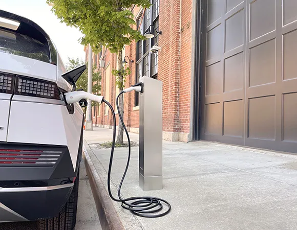 Electric vehicle parked outside a home with a charging cable connected to the charging station.